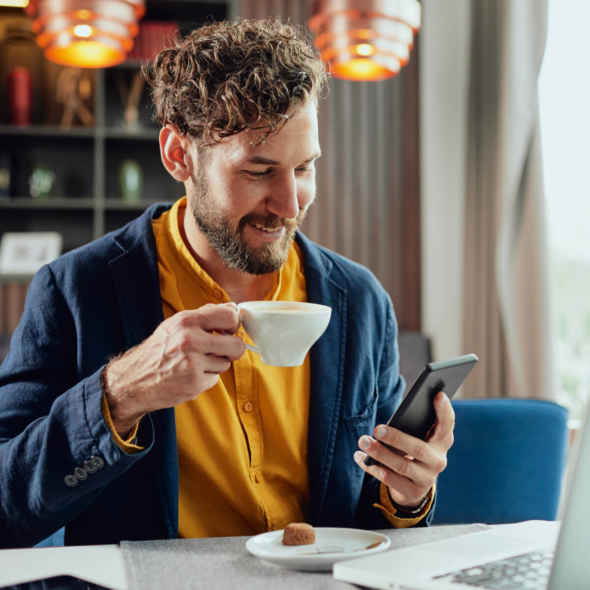 Man-Enjoying-Coffee-While-Using-Smartphone